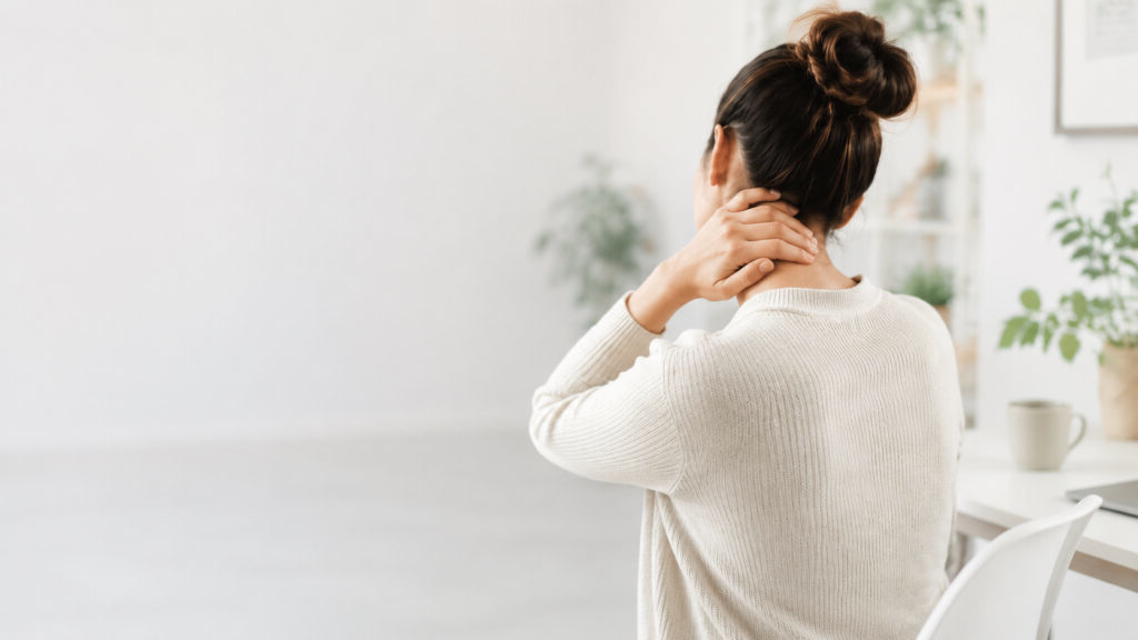 A woman holding the back of her neck